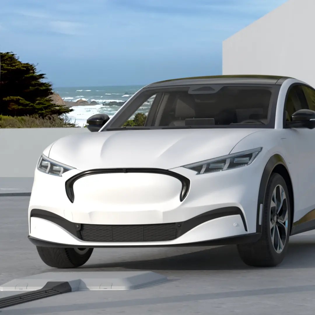 A white electric vehicle is parked in a seaside outdoor parking garage and is pulling into a wireless EV charging spot