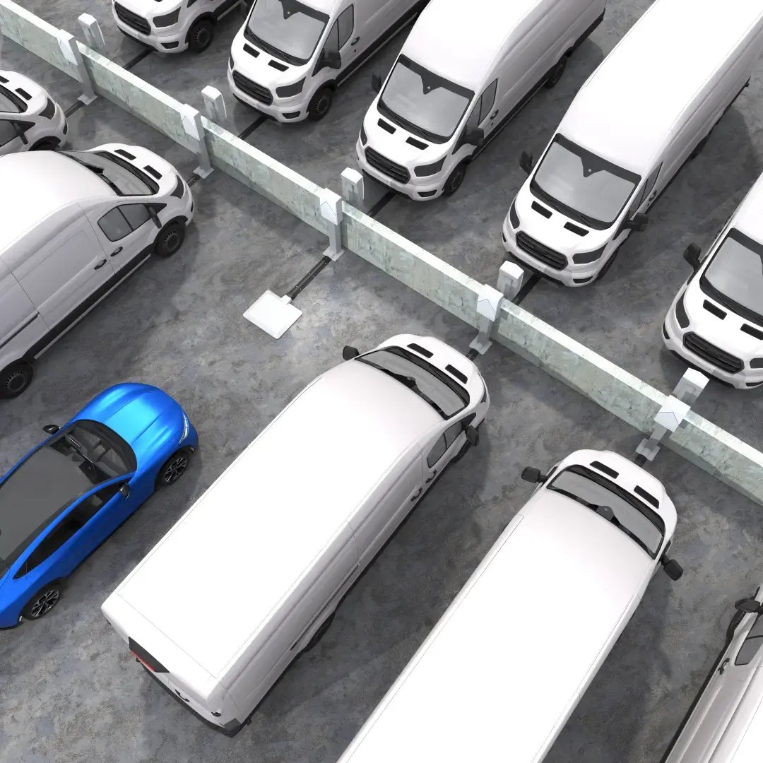 A blue car approaches a wireless EV charger in a parking lot next to vans charging wirelessly