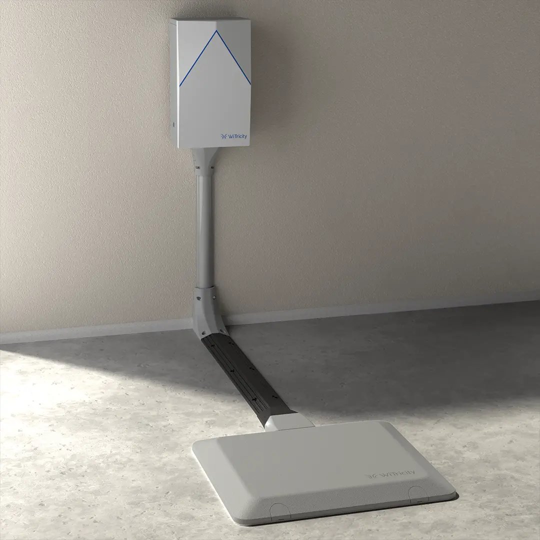 Detailed image of WiTricity wireless charging system with charging pad and wall box in a brightly lit garage