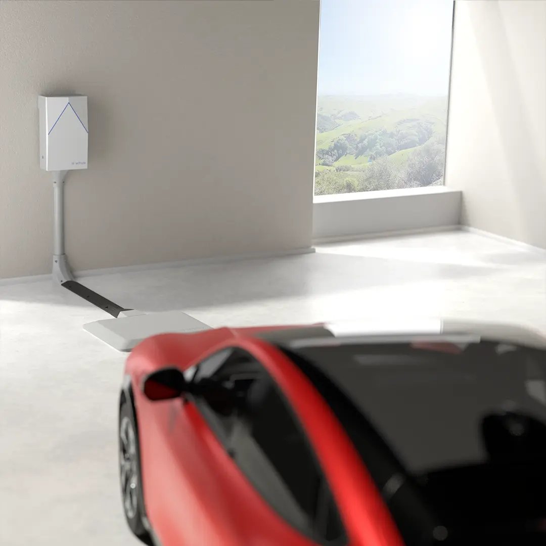 Red sports car approaches an EV wireless charging pad inside a beautiful garage with the sunlight pouring in through the window.