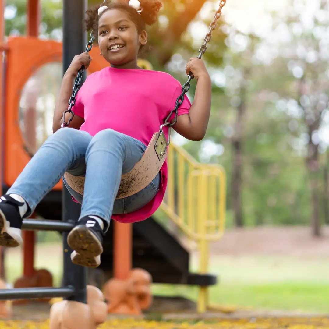 Child swinging in playground