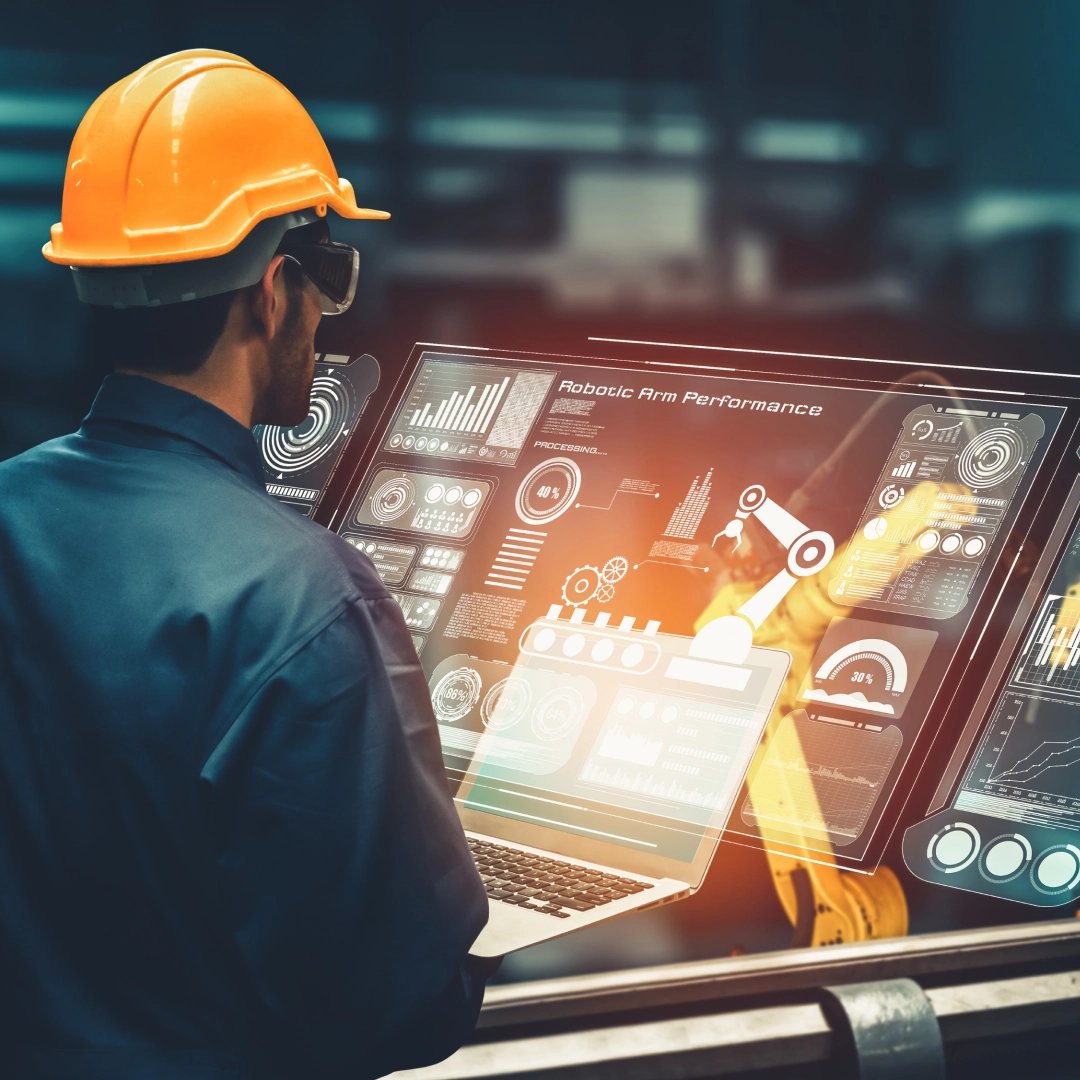 An auto manufacturing worker monitoring the robotics arm on a screen in the assembly line.