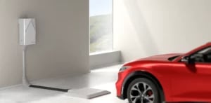 Interior garage with a window, wall mount, and wireless charging pad, featuring a red electric car.
