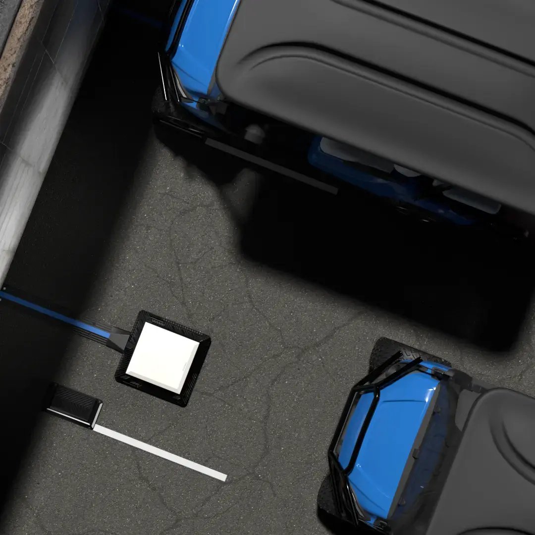 A golf cart drives up to a wireless EV charger in an industrial parking lot as viewed from the top