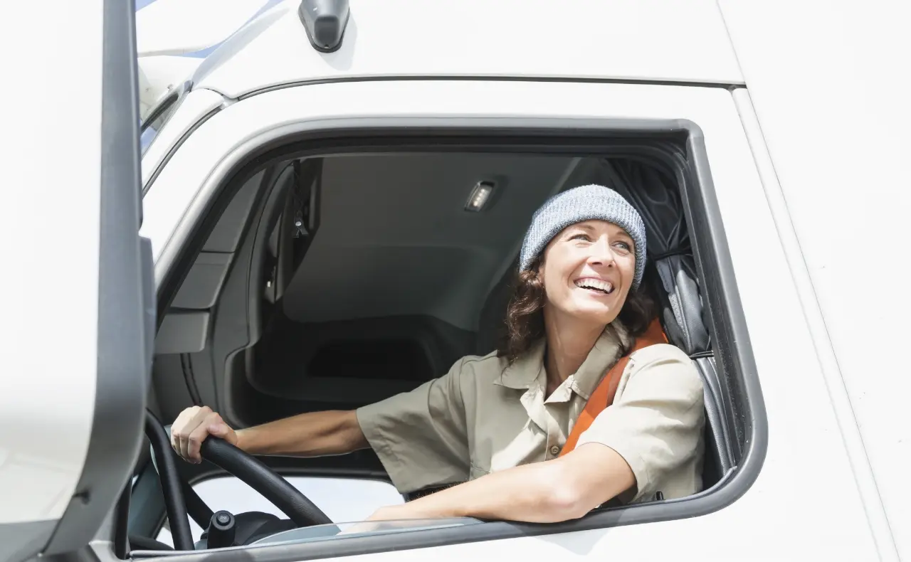 Driver of a work van is smiling as they look out the window